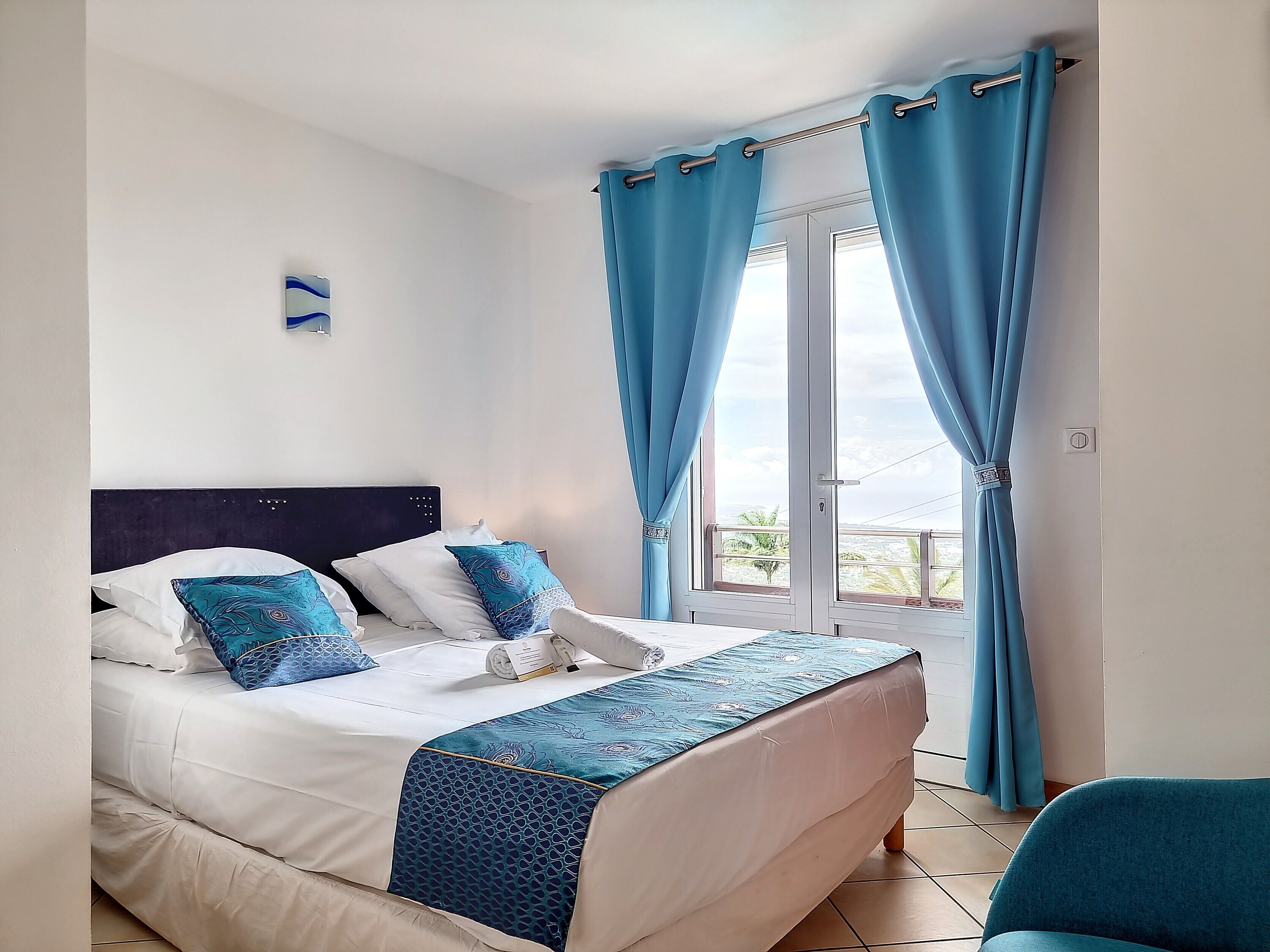 A neatly made bed with a patterned bedspread, a headboard, and decorative pillows.