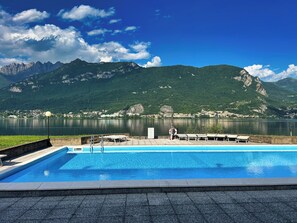 Une piscine avec vue sur les montagnes et un lac.