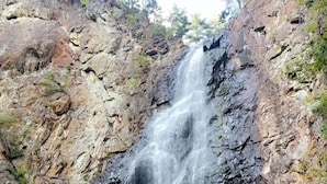 A waterfall cascading down a rocky cliff into a pool. - Rustic Fishing Lodge located on the Main Southwest Miramichi (Bloomfield Ridge)