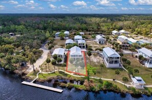 An aerial view of a residential area with houses, a dock, and a water body. - The Blue Heron at River's Bend - Steinhatchee (Steinhatchee)