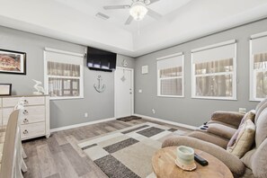 Ein Wohnzimmer mit Sofa, Couchtisch, Fernseher und Kamin.