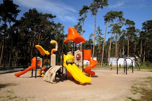 Ein Spielplatz mit Rutschen und Klettergeräten.