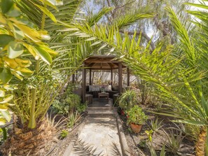 A garden pathway leading to a wooden gazebo with seating. - CHL Villa Abraham, Private Pool & Relax (Puerto del Rosario)