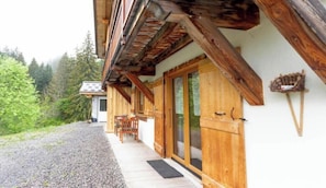 A wooden cabin with a porch, a door, and a small table. - LA BARTAVELLE - LA GIETTAZ (LA GIETTAZ)