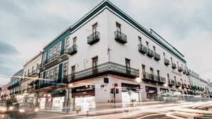 A multi-story building with balconies, storefronts, and a street view. - Best Western San Pedro Puebla (Puebla)