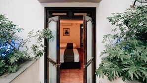 A narrow entrance to a room with a bed and a framed picture on the wall. - Best Western San Pedro Puebla (Puebla)