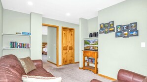 Ein Wohnzimmer mit einem braunen Ledersofa, einer Holz-Unterhaltungseinheit und einem Bücherregal.
