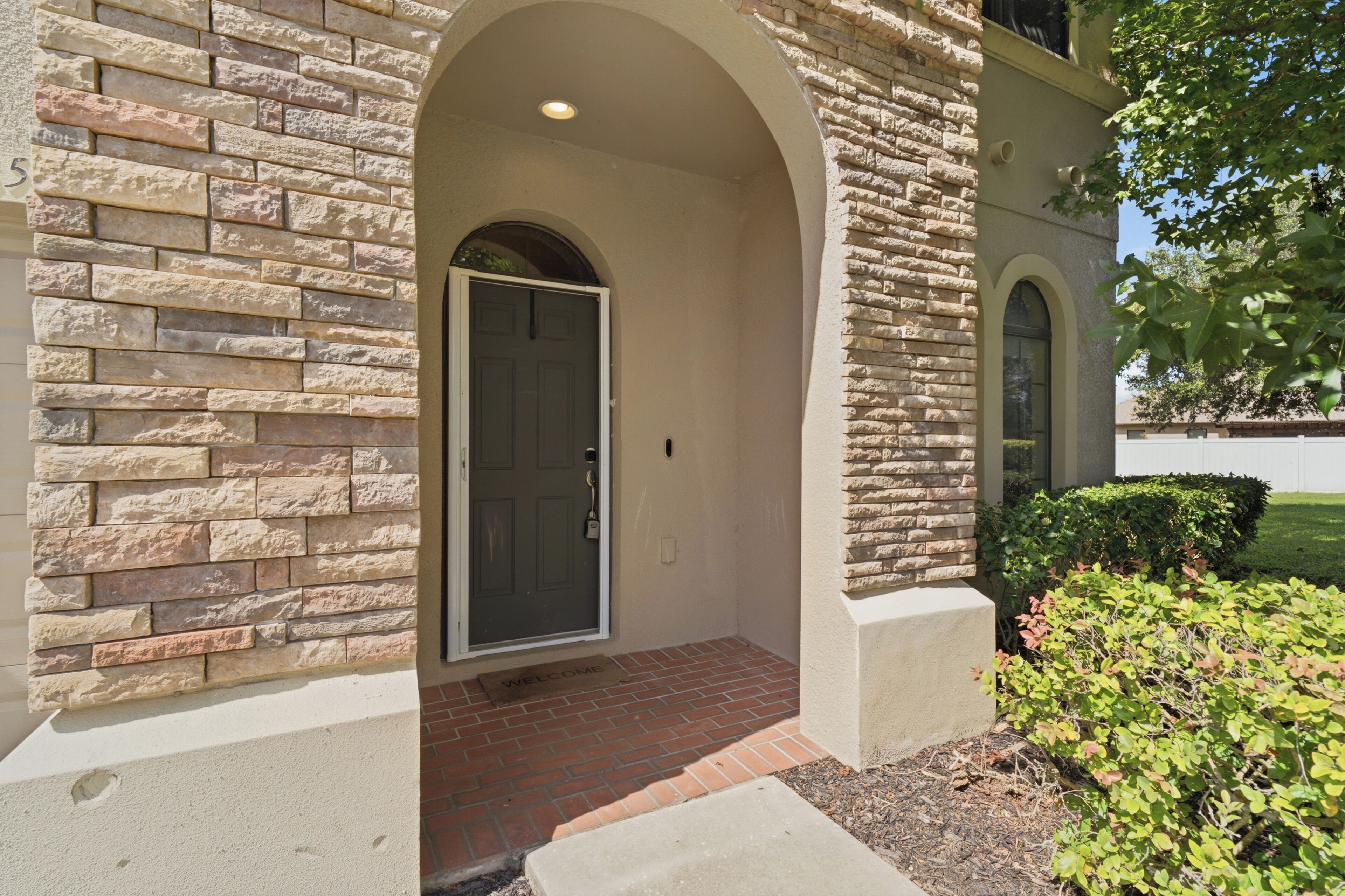 A building entrance with a stone facade, a door, and a small porch area.