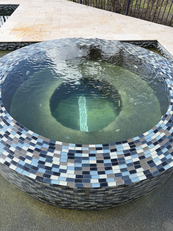 Una piscina circular con bordes de mosaicos.