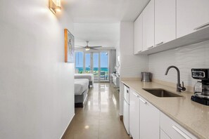 Eine moderne Küche mit Spüle, Kaffeemaschine und Blick ins Freie.