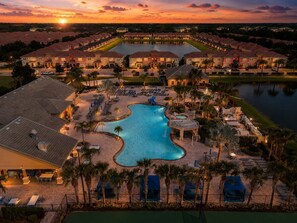 Ein Resort mit einem großen Schwimmbad, mehreren Liegebereichen und Blick auf die umliegende Nachbarschaft.