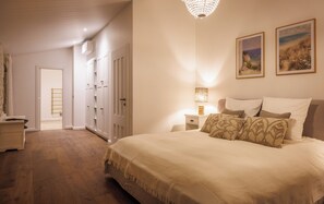 A bedroom with a large bed, a nightstand, a lamp, a wardrobe, and two framed pictures on the wall. - Your Villa Réthaise for 10 People with Heated Indoor Pool (Sainte-Marie-de-Ré)