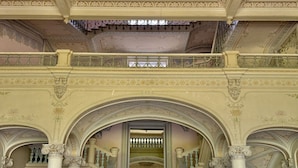 Eine prachtvolle Treppe mit aufwendiger Geländer- und Säulenornierung, die zu einem großen Eingang führt.