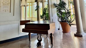 Ein prunkvoller Raum mit klassischer Architektur, darunter Säulen, Bögen und aufwändige Deckenfresken.