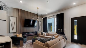 Een moderne woonkamer met een bank, televisie en een open haard.