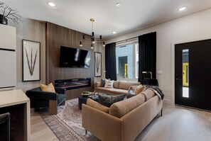 Ein modernes Wohnzimmer mit einer Couch, einem Fernseher und einem Kamin.