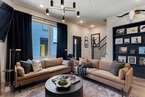 Ein modernes Wohnzimmer mit zwei Sofas, einem Couchtisch und einer Treppe.