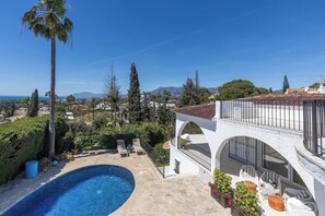 A poolside area with a clear view of the surrounding landscape, including trees and distant mountains. - Casa Mariposa - Elviria, Marbella (Marbella)