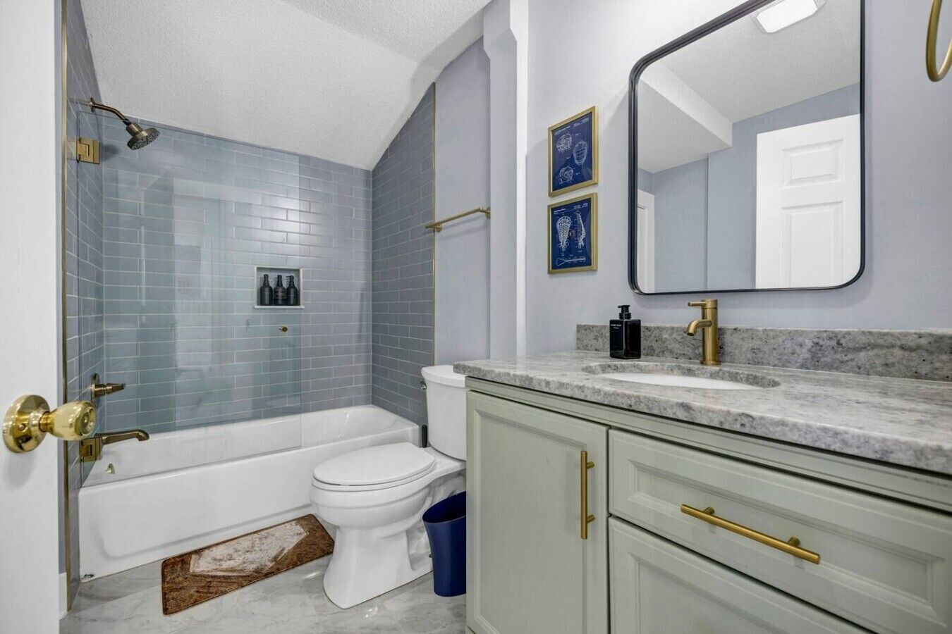 A bathroom with a bathtub, toilet, and vanity with a mirror.