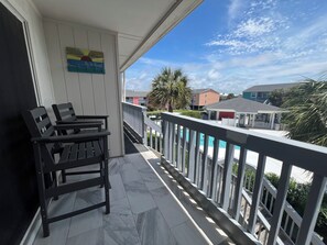 A balcony with a view of a swimming pool and buildings.
