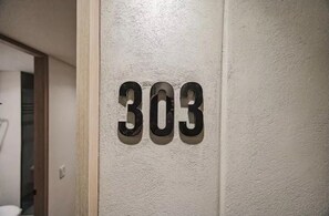 Eine Wand mit der Nummer 303 in einem Zimmer.