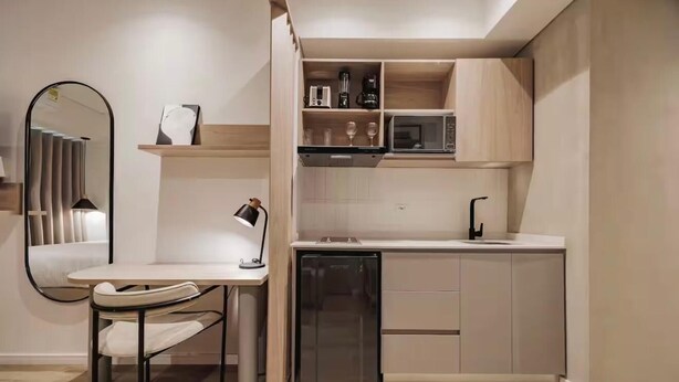 A compact kitchen with a microwave, coffee maker, and a small refrigerator. - Laureles Studio 303Q (Medellín)