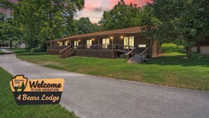 A lodge with a porch, a staircase, and a sign welcoming visitors to the adventure. - 4 Bears Lodge at Edgewater - Entire Lodge 6 Rooms (Forsyth)