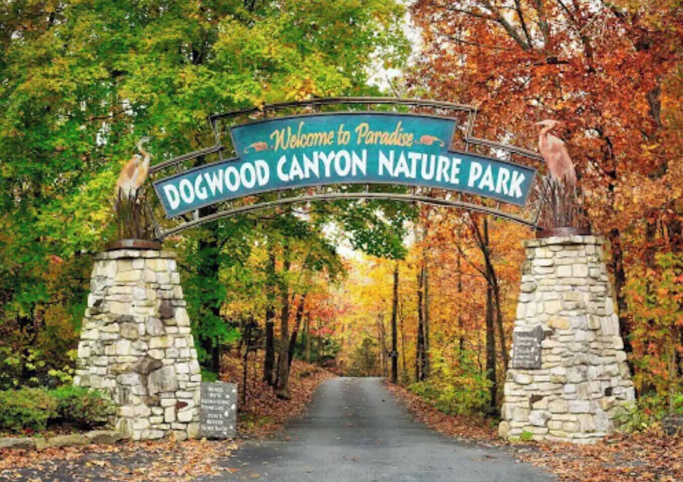 Une arche en pierre surmontée d’une enseigne indiquant : « Bienvenue au parc naturel de Paradise Dogwood Canyon. »