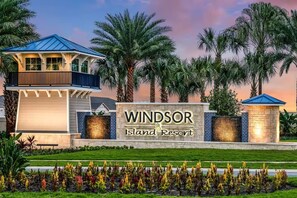 Ein Resort mit einem Schild, auf dem 'Windsor Island Resort' steht, umgeben von Palmen und einem gepflegten Rasen.