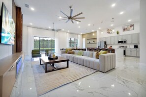 Ein modernes Wohnzimmer mit einer Couch, einem Couchtisch und Deckenventilatoren.