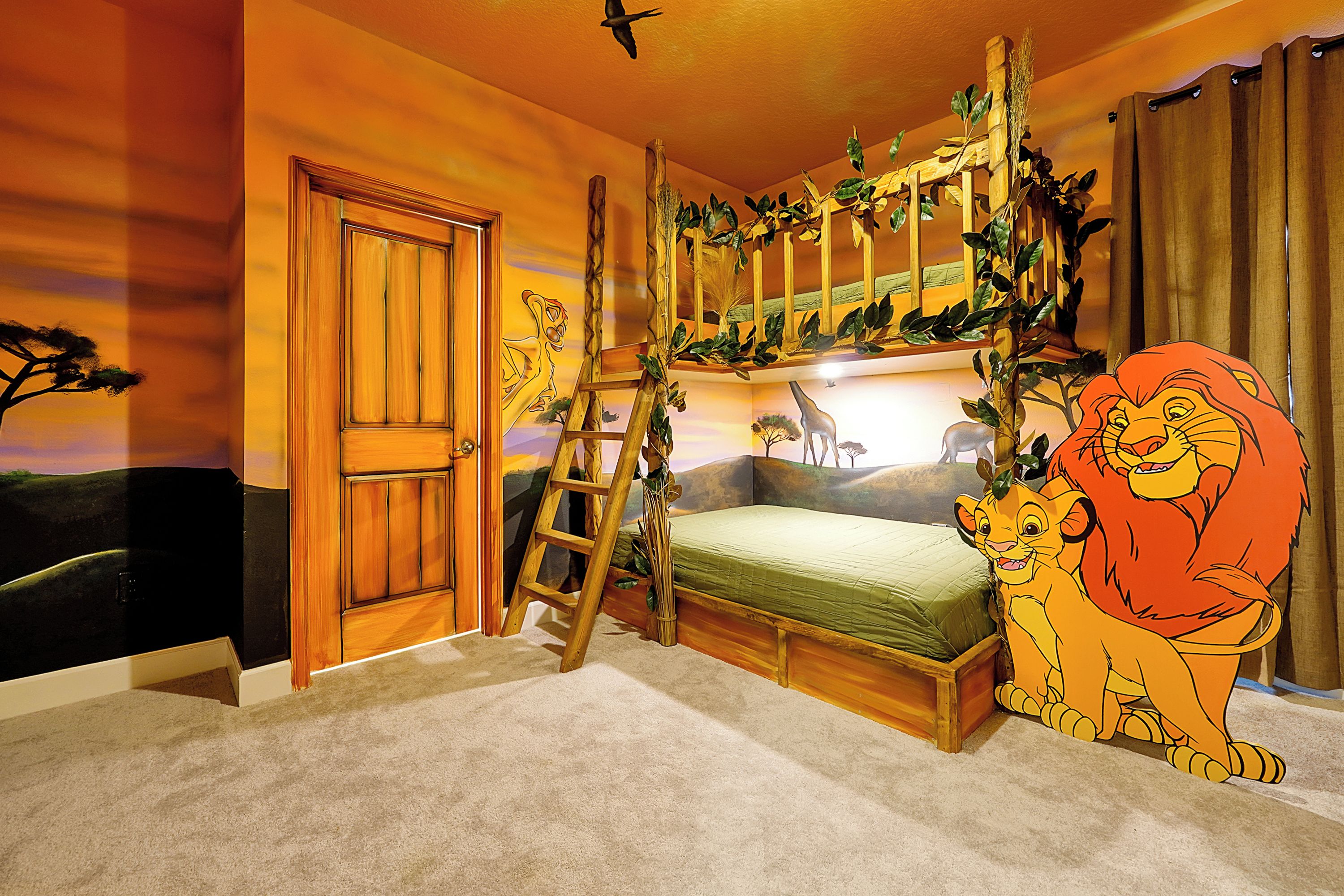 Une chambre avec un lit superposé, une échelle, une porte et une fresque représentant un lion.