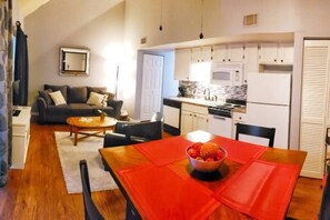 Ein kompakter Wohnraum mit Essbereich, Küchenzeile und einer Couch im Wohnzimmer.