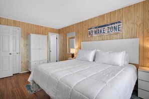 Un dormitorio con cama, mesita de noche, cómoda y un cartel en la pared que indica 'NO WAKE ZONE'.