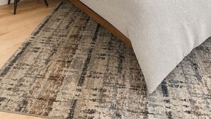 Ein Schlafzimmer mit Bett, Nachttisch und Fenster mit Jalousien.