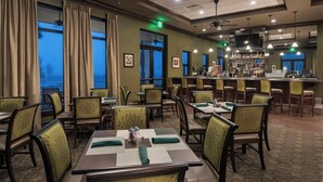 A restaurant with tables and chairs, a bar area, and large windows with curtains. - SARASOTA NATIONAL - SEASONAL RENTAL -WITH GOLF MEMBERSHIP FOR 2 - 3 BR/2 BATH (Venice)