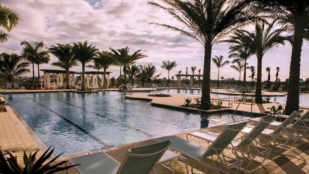 A swimming pool with lounge chairs, palm trees, and a clear sky. - SARASOTA NATIONAL - SEASONAL RENTAL -WITH GOLF MEMBERSHIP FOR 2 - 3 BR/2 BATH (Venice)