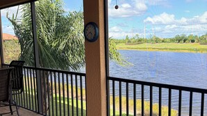 A covered outdoor area with a view of a body of water, a clock, and a chair. - SARASOTA NATIONAL - SEASONAL RENTAL -WITH GOLF MEMBERSHIP FOR 2 - 3 BR/2 BATH (Venice)
