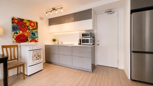 Une cuisine moderne avec un four blanc, un four à micro-ondes et un réfrigérateur en acier inoxydable.