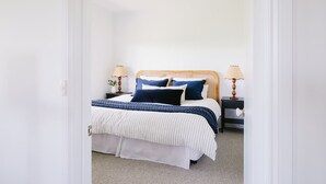 A bedroom with a bed, two bedside tables, and a nightstand. - Suma Park Estate (Marcus Hill)