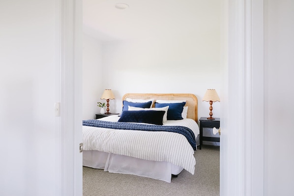A bedroom with a bed, two bedside tables, and a nightstand.