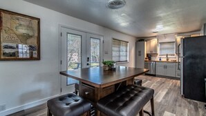 A modern kitchen with a central island, dark leather bar stools, and a large map on the wall. - Gulfside Getaway Awaits (Corpus Christi)