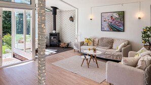 Ein modernes Wohnzimmer mit Kamin, einer Couch, einem Couchtisch und einem Gemälde an der Wand.