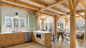 A spacious kitchen with wooden cabinetry, a central island, and a dining area with a round table and chairs.