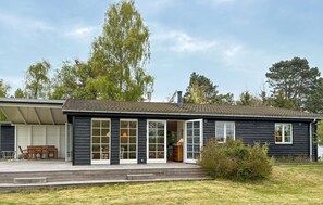 Ein zweistöckiges Haus mit Garage, überdachter Veranda und kleinem Vorgarten.