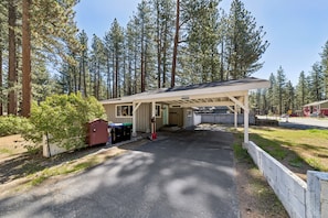 A cabin with a covered porch, a small shed, and a garage.