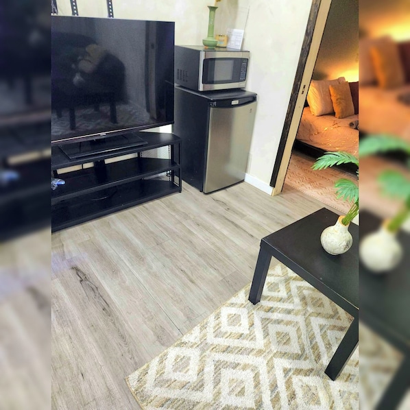 A living room with a TV, a small table, and a sofa.