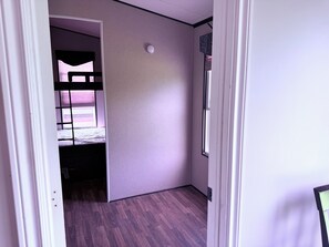 A room with a bunk bed, a small window, and a door. - Garden Resort of Niagara Retreat Center  (Niagara Falls)
