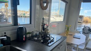 Una cocina con estufa a gas, un fregadero y vistas amplias a un puerto deportivo.
