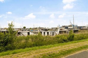 Un port de plaisance avec des bateaux amarrés, de petits bâtiments et une zone herbeuse.