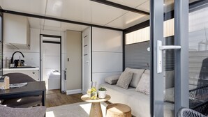 Un intérieur moderne comprenant un coin repas, un canapé et une porte vitrée donnant sur l’extérieur.